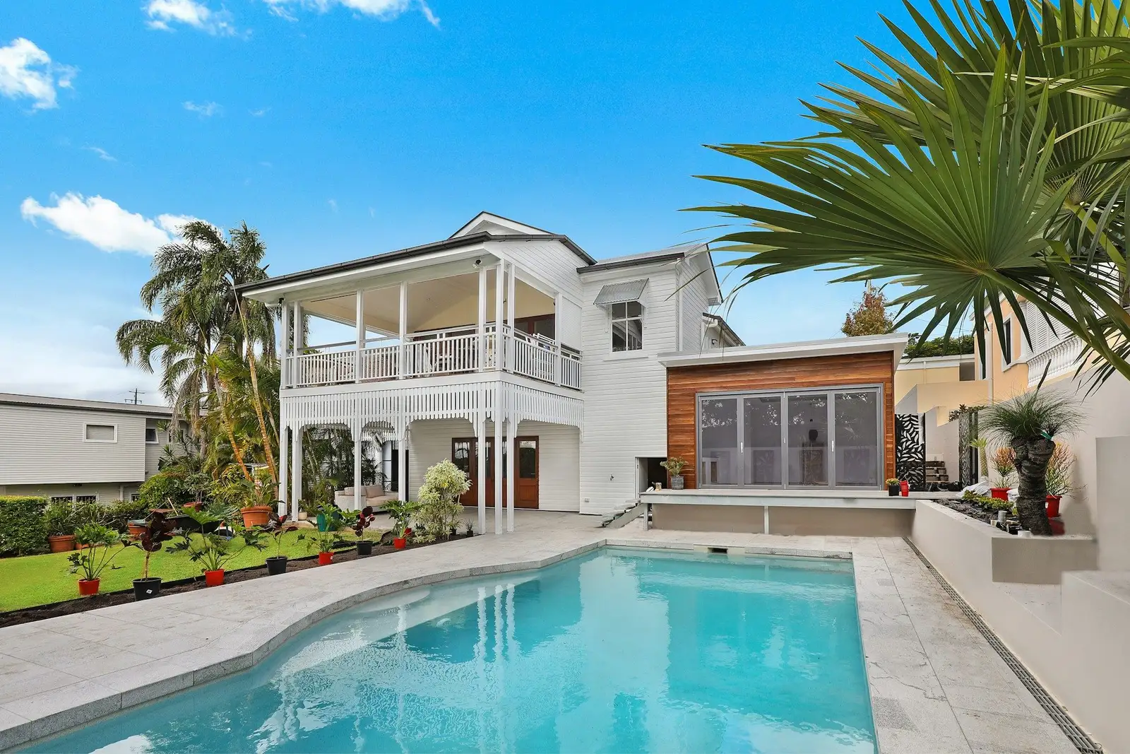 Two-storey white house with a veranda and a pool