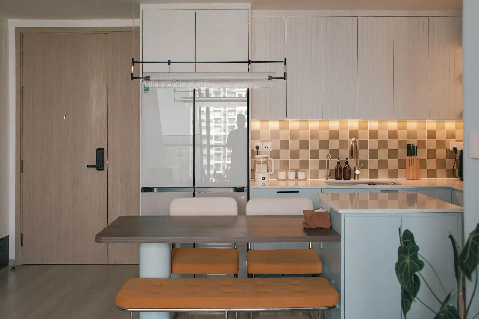 Kitchen with a checked tile backsplash and a bench table by the entry