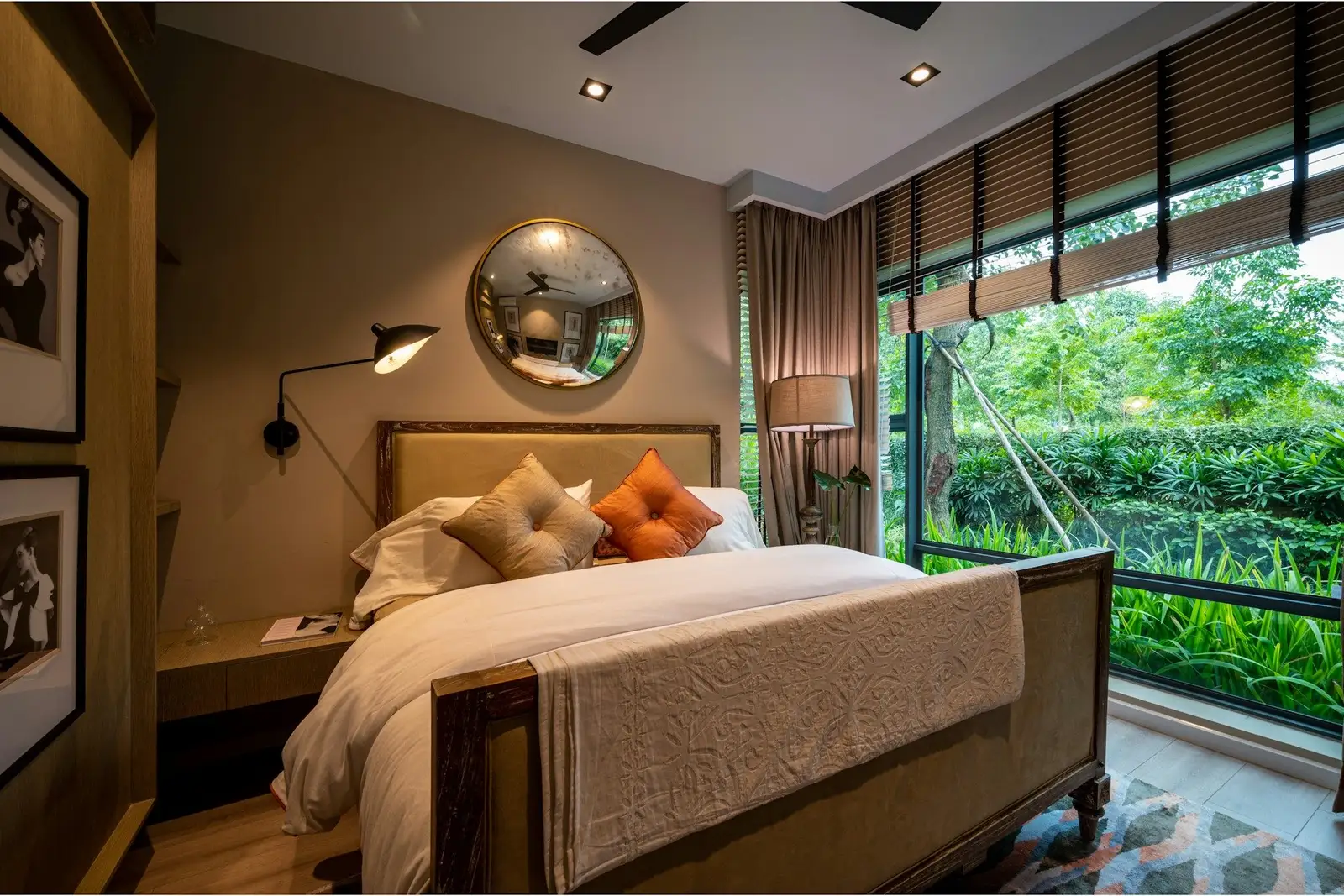 Bedroom with an upholstered bed and a glass wall onto a garden