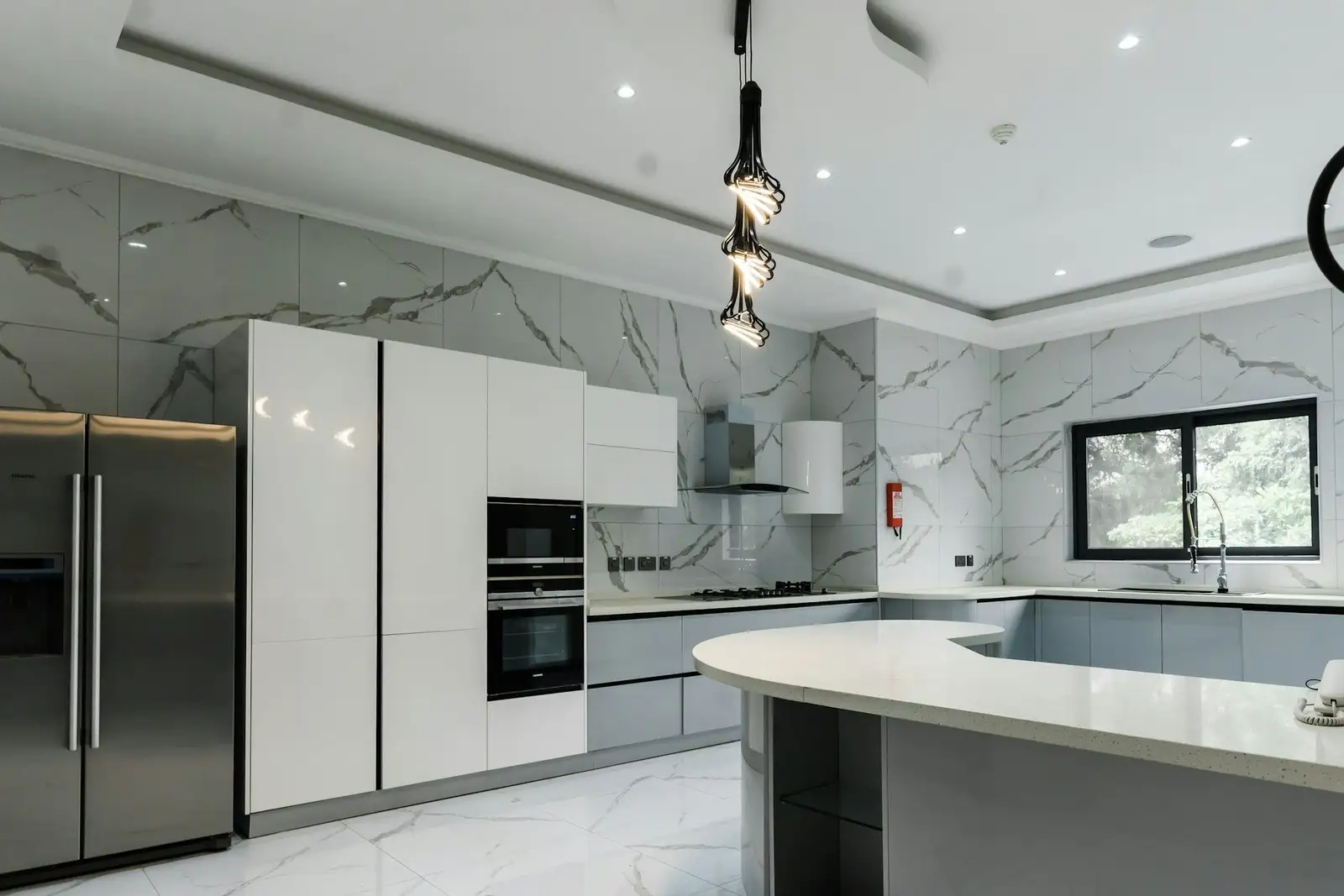 White kitchen with marble walls and a curved counter
