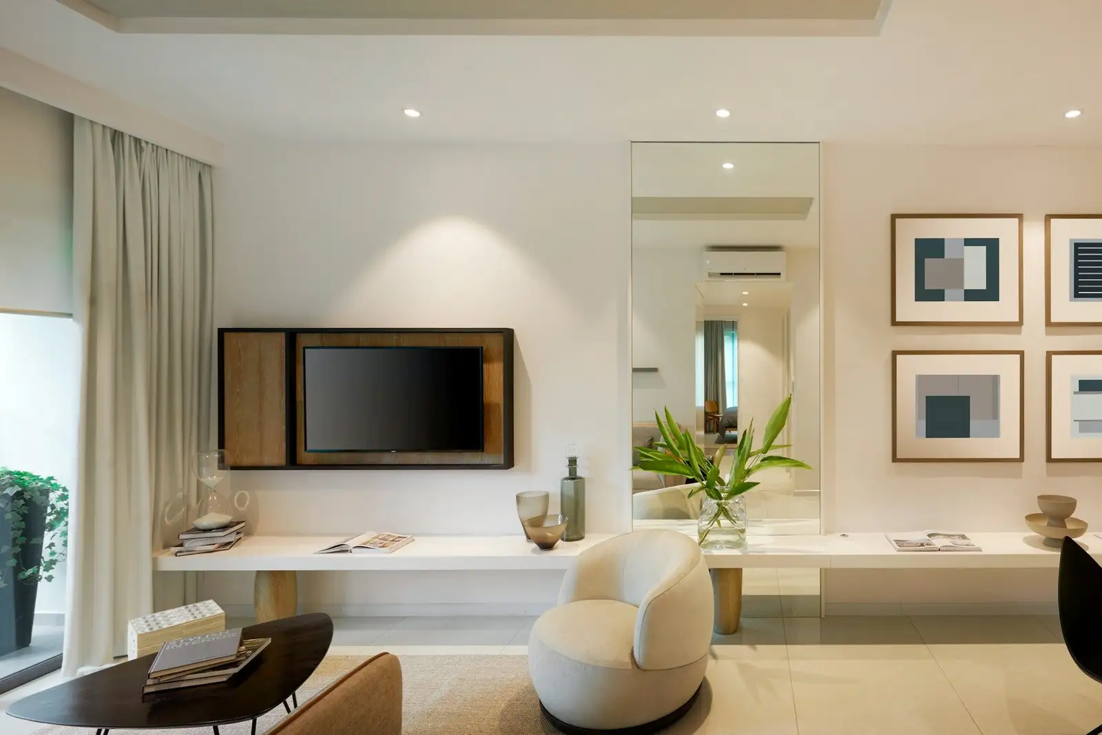 Bright living room with a wall-mounted TV, an armchair and framed prints