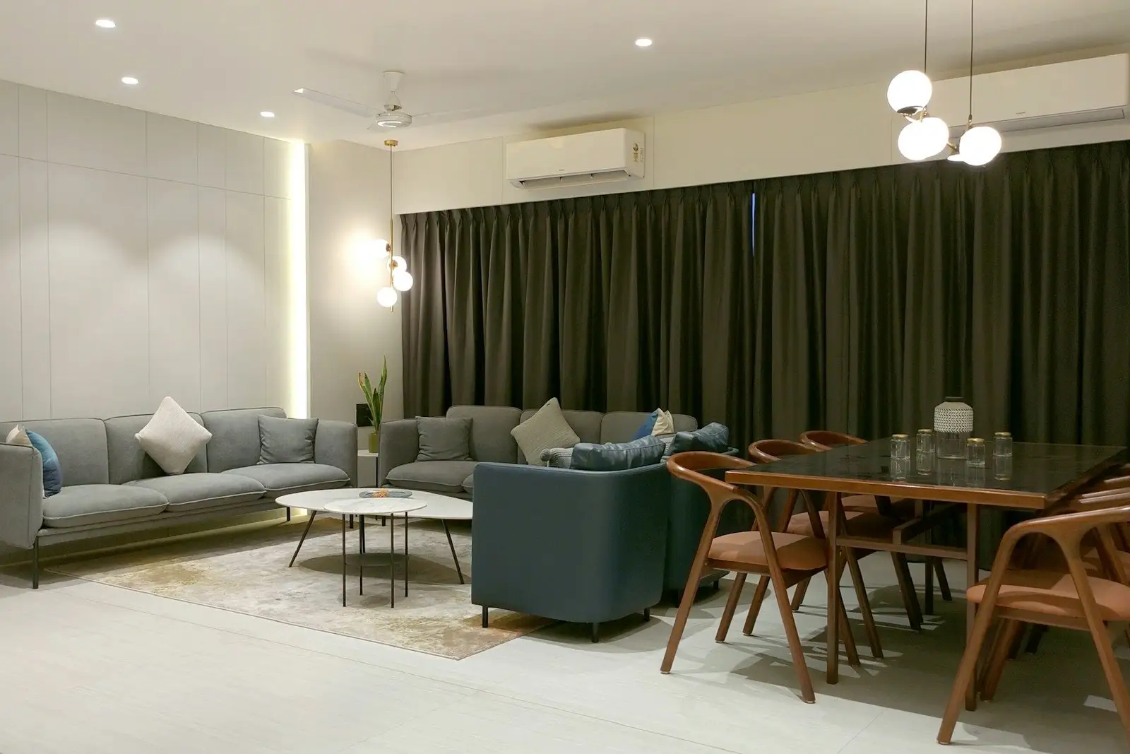 Living and dining room with grey sofas and a wooden dining set