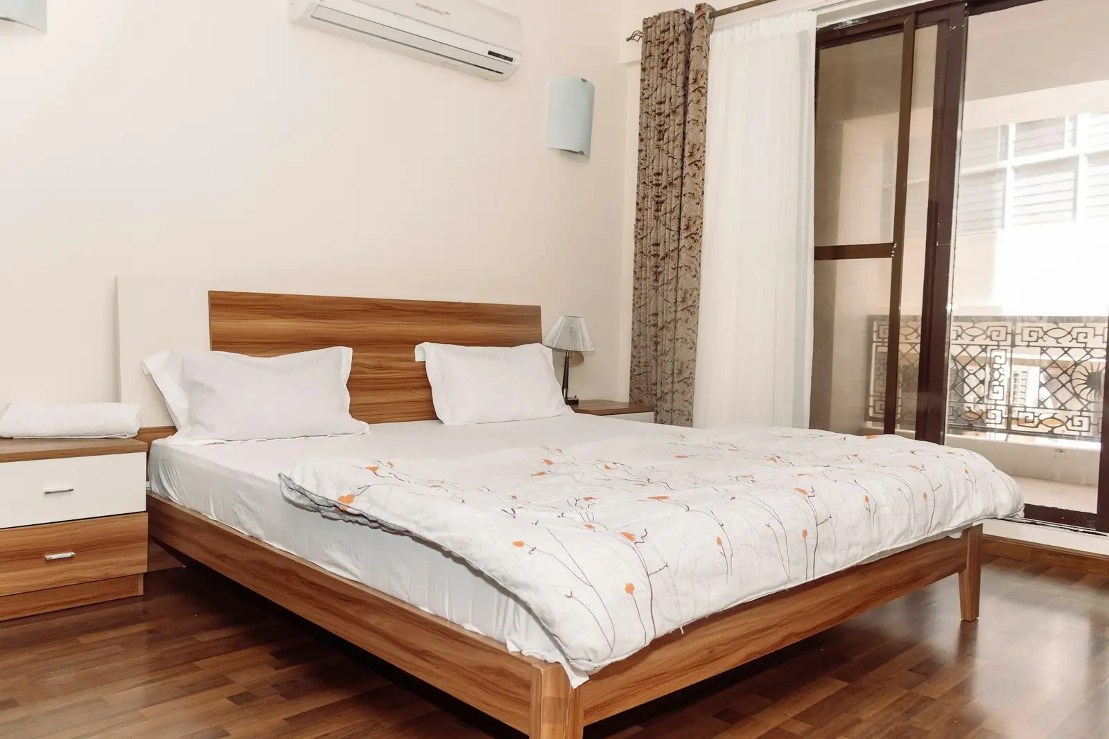 Bedroom with a wooden bed and a sliding door to a balcony