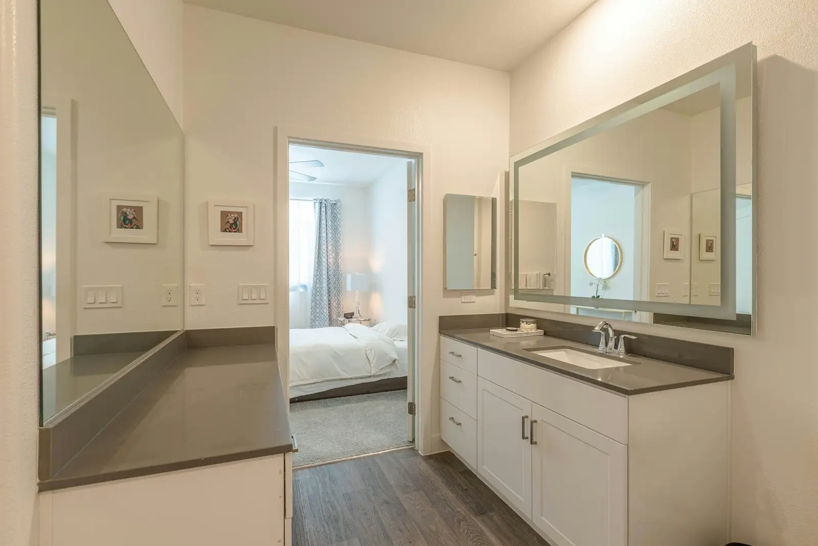 Bathroom with a long vanity and a door to the bedroom